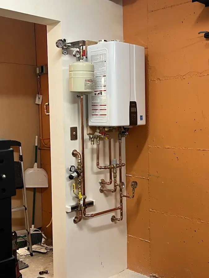 Plumbing technician inspecting water heater connections in Somerville